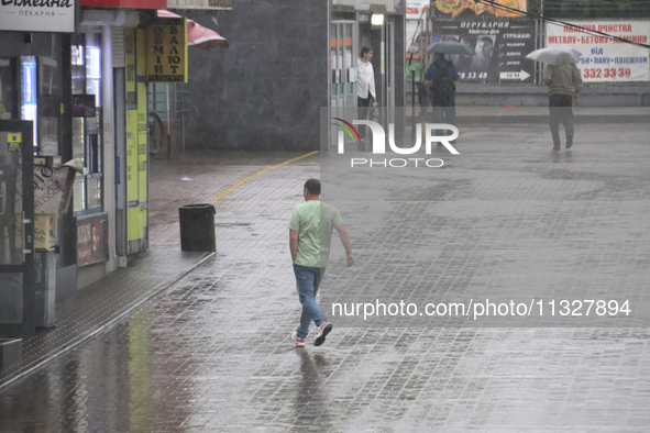 A man is running under heavy rain, which is amounting to half of the monthly average, in Kyiv, Ukraine, on June 12, 2024. NO USE RUSSIA. NO...