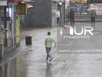 A man is running under heavy rain, which is amounting to half of the monthly average, in Kyiv, Ukraine, on June 12, 2024. NO USE RUSSIA. NO...