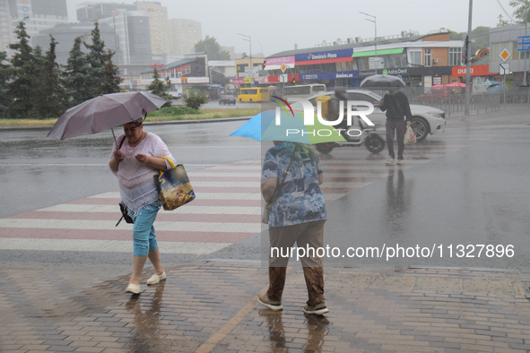 Pedestrians are walking under umbrellas during heavy rain, which is amounting to half of the monthly average, in Kyiv, Ukraine, on June 12,...