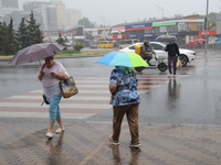 Pedestrians are walking under umbrellas during heavy rain, which is amounting to half of the monthly average, in Kyiv, Ukraine, on June 12,...