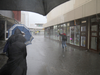 People are walking along a street with umbrellas during heavy rain, which is amounting to half of the monthly average, in Kyiv, Ukraine, on...