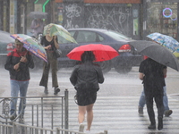 People are crossing a street with umbrellas during heavy rain, which is amounting to half of the monthly average, in Kyiv, Ukraine, on June...