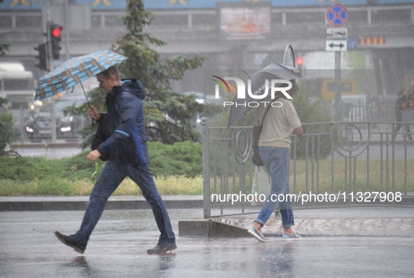 Pedestrians are walking under umbrellas during heavy rain, which is amounting to half of the monthly average, in Kyiv, Ukraine, on June 12,...