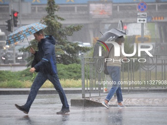 Pedestrians are walking under umbrellas during heavy rain, which is amounting to half of the monthly average, in Kyiv, Ukraine, on June 12,...