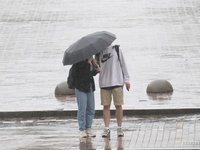 A man and woman are sharing an umbrella during heavy rain, which is amounting to half of the monthly average, in Kyiv, Ukraine, on June 12,...