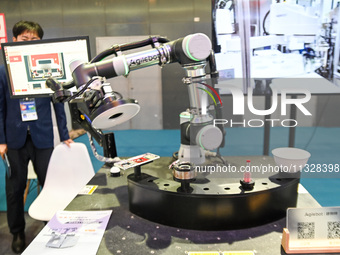 An intelligent collaborative robot is demonstrating a flybat inspection product at The 10th China (Shanghai) International Technology Fair i...