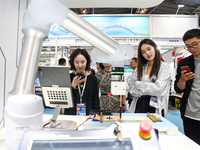 Visitors are watching a calligraphy robot write at The 10th China (Shanghai) International Technology Fair in Shanghai, China, on June 13, 2...