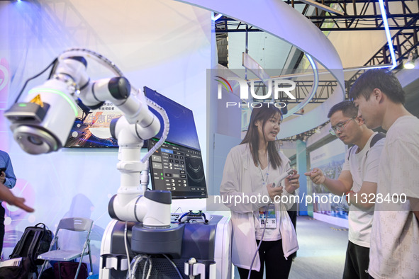 Visitors are visiting an ultrasound therapy robot at The 10th China (Shanghai) International Technology Fair in Shanghai, China, on June 13,...