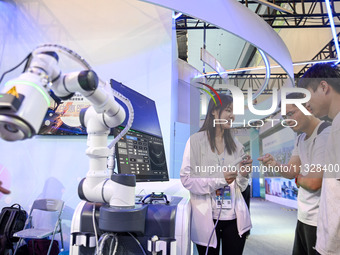 Visitors are visiting an ultrasound therapy robot at The 10th China (Shanghai) International Technology Fair in Shanghai, China, on June 13,...