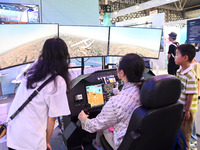 Visitors are experiencing a flight simulation simulator at The 10th China (Shanghai) International Technology Fair in Shanghai, China, on Ju...