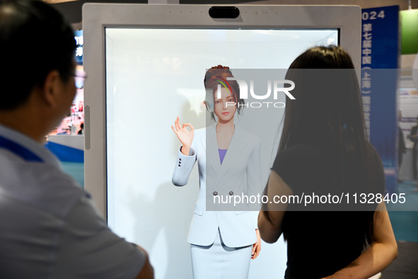 Audience members are talking to a mock host at The 10th China (Shanghai) International Technology Fair in Shanghai, China, on June 13, 2024....