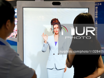 Audience members are talking to a mock host at The 10th China (Shanghai) International Technology Fair in Shanghai, China, on June 13, 2024....