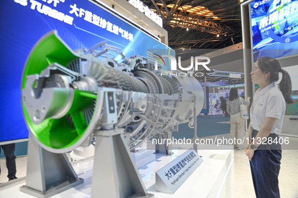 Visitors are viewing a model exhibit of a heavy-duty hydrogen-doped gas turbine at The 10th China (Shanghai) International Technology Fair i...