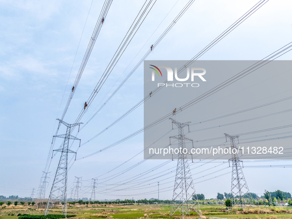 Power supply workers are carrying out acceptance work on a new 500-kilovolt transmission line in Nanjing, Jiangsu province, China, on June 1...