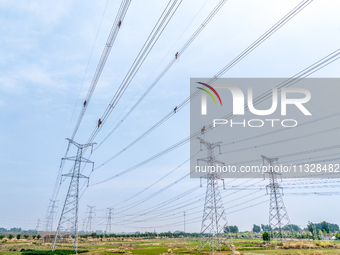 Power supply workers are carrying out acceptance work on a new 500-kilovolt transmission line in Nanjing, Jiangsu province, China, on June 1...