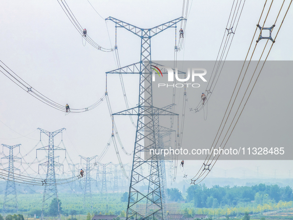 Power supply workers are carrying out acceptance work on a new 500-kilovolt transmission line in Nanjing, Jiangsu province, China, on June 1...