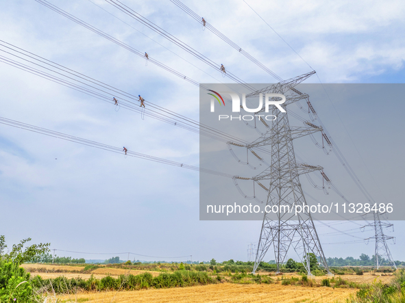 Power supply workers are carrying out acceptance work on a new 500-kilovolt transmission line in Nanjing, Jiangsu province, China, on June 1...