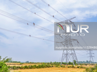 Power supply workers are carrying out acceptance work on a new 500-kilovolt transmission line in Nanjing, Jiangsu province, China, on June 1...