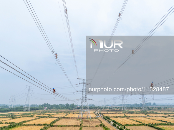 Power supply workers are carrying out acceptance work on a new 500-kilovolt transmission line in Nanjing, Jiangsu province, China, on June 1...