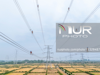 Power supply workers are carrying out acceptance work on a new 500-kilovolt transmission line in Nanjing, Jiangsu province, China, on June 1...