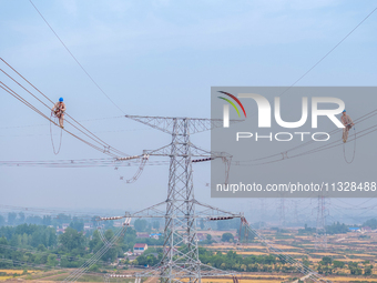 Power supply workers are carrying out acceptance work on a new 500-kilovolt transmission line in Nanjing, Jiangsu province, China, on June 1...