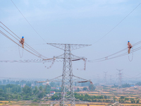 Power supply workers are carrying out acceptance work on a new 500-kilovolt transmission line in Nanjing, Jiangsu province, China, on June 1...