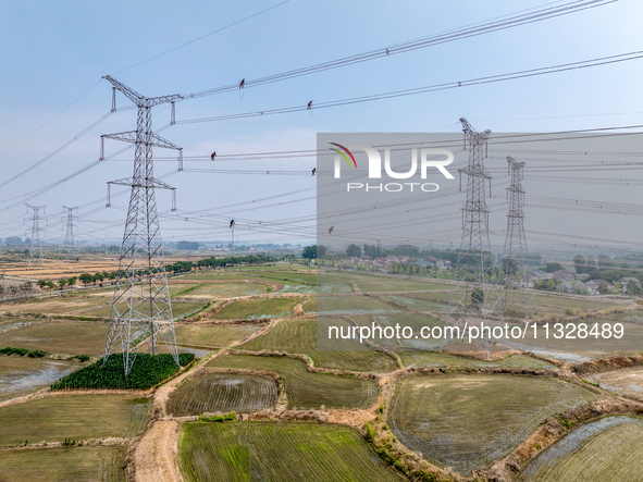 Power supply workers are carrying out acceptance work on a new 500-kilovolt transmission line in Nanjing, Jiangsu province, China, on June 1...