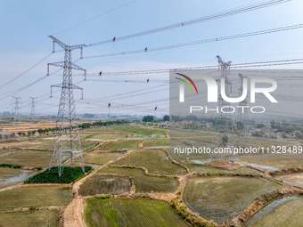 Power supply workers are carrying out acceptance work on a new 500-kilovolt transmission line in Nanjing, Jiangsu province, China, on June 1...