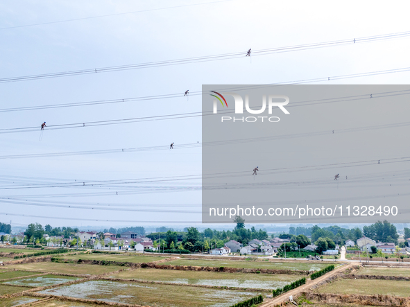 Power supply workers are carrying out acceptance work on a new 500-kilovolt transmission line in Nanjing, Jiangsu province, China, on June 1...