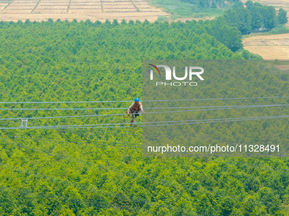 Power supply workers are carrying out acceptance work on a new 500-kilovolt transmission line in Nanjing, Jiangsu province, China, on June 1...