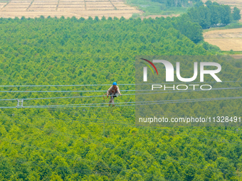 Power supply workers are carrying out acceptance work on a new 500-kilovolt transmission line in Nanjing, Jiangsu province, China, on June 1...