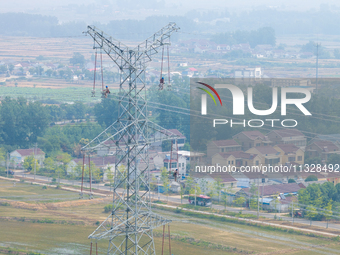 Power supply workers are carrying out acceptance work on a new 500-kilovolt transmission line in Nanjing, Jiangsu province, China, on June 1...