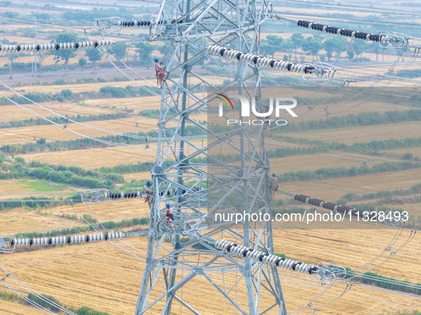 Power supply workers are carrying out acceptance work on a new 500-kilovolt transmission line in Nanjing, Jiangsu province, China, on June 1...