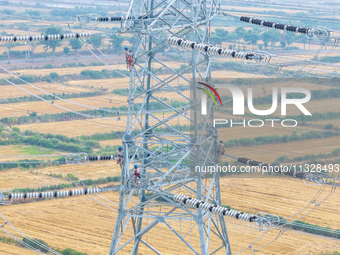 Power supply workers are carrying out acceptance work on a new 500-kilovolt transmission line in Nanjing, Jiangsu province, China, on June 1...