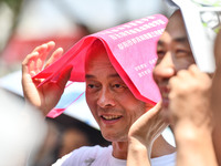 Citizens are wearing sun-protective clothing and riding on a street under high temperatures in Fuyang, China, on June 14, 2024. (