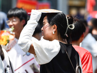 Citizens are wearing sun-protective clothing and riding on a street under high temperatures in Fuyang, China, on June 14, 2024. (