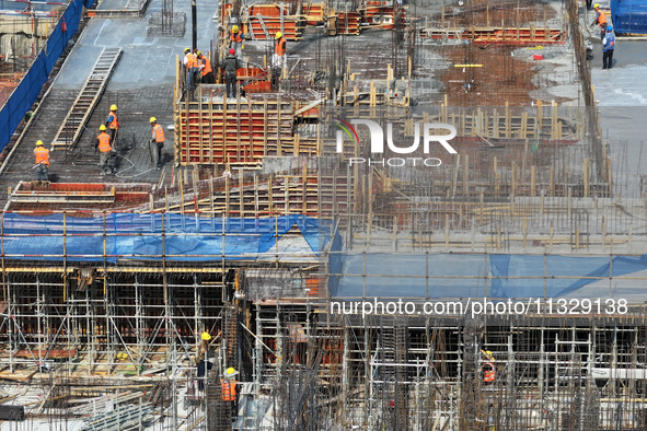 Workers are working outdoors at a commercial housing construction site in Nanjing, China, on June 14, 2024, when the temperature is exceedin...