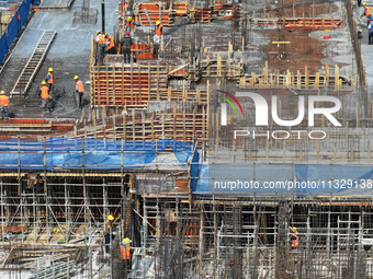 Workers are working outdoors at a commercial housing construction site in Nanjing, China, on June 14, 2024, when the temperature is exceedin...