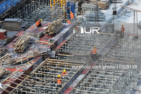 Workers are working outdoors at a commercial housing construction site in Nanjing, China, on June 14, 2024, when the temperature is exceedin...