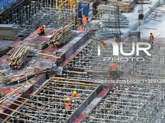 Workers are working outdoors at a commercial housing construction site in Nanjing, China, on June 14, 2024, when the temperature is exceedin...