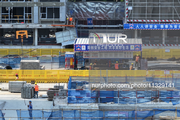 Workers are working outdoors at a commercial housing construction site in Nanjing, China, on June 14, 2024, when the temperature is exceedin...