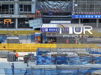 Workers are working outdoors at a commercial housing construction site in Nanjing, China, on June 14, 2024, when the temperature is exceedin...