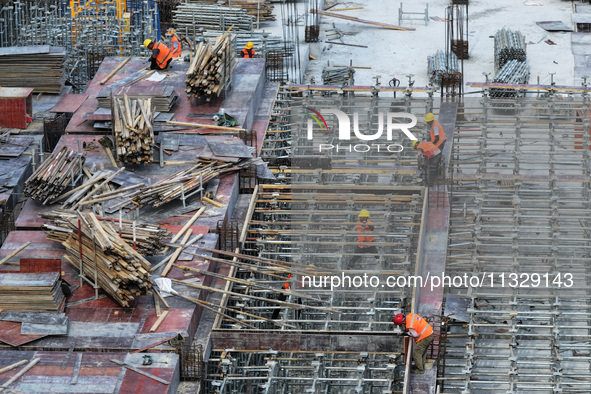 Workers are working outdoors at a commercial housing construction site in Nanjing, China, on June 14, 2024, when the temperature is exceedin...