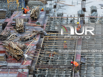 Workers are working outdoors at a commercial housing construction site in Nanjing, China, on June 14, 2024, when the temperature is exceedin...