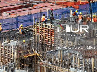 Workers are working outdoors at a commercial housing construction site in Nanjing, China, on June 14, 2024, when the temperature is exceedin...