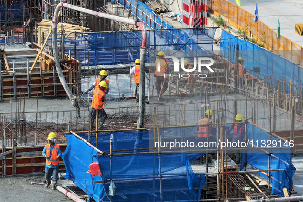 Workers are working outdoors at a commercial housing construction site in Nanjing, China, on June 14, 2024, when the temperature is exceedin...