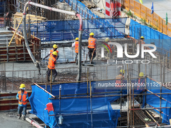 Workers are working outdoors at a commercial housing construction site in Nanjing, China, on June 14, 2024, when the temperature is exceedin...