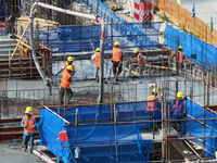 Workers are working outdoors at a commercial housing construction site in Nanjing, China, on June 14, 2024, when the temperature is exceedin...