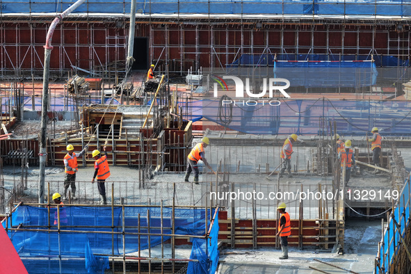 Workers are working outdoors at a commercial housing construction site in Nanjing, China, on June 14, 2024, when the temperature is exceedin...