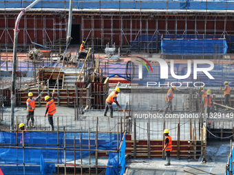 Workers are working outdoors at a commercial housing construction site in Nanjing, China, on June 14, 2024, when the temperature is exceedin...